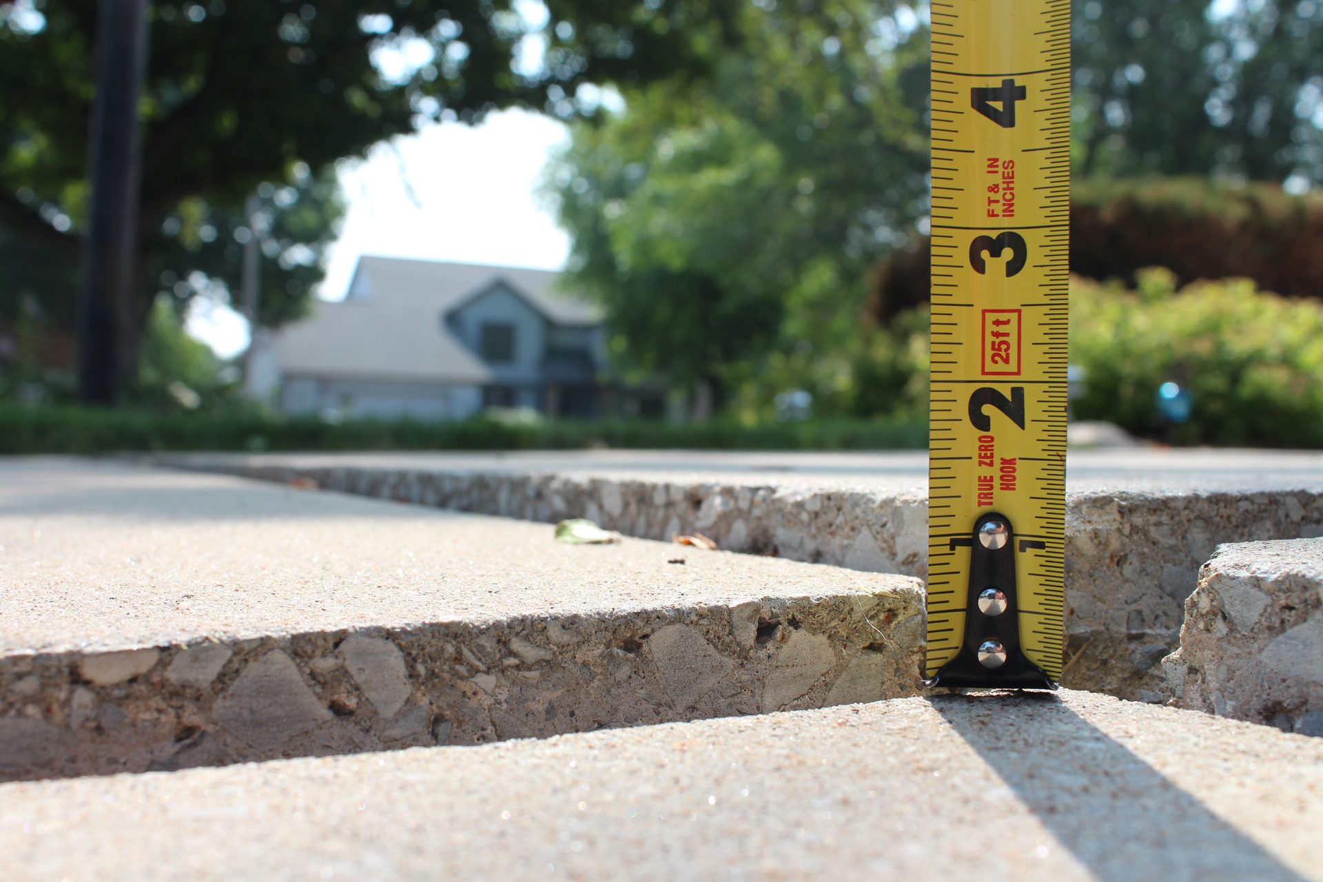 Sunken concrete walkway with visible settlement before foam lifting